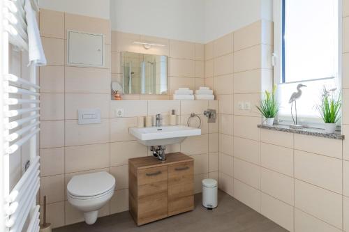 a bathroom with a toilet and a sink at Ferienwohnung SeeNest am Röbeler Stadthafen - Neubau 2025 in Röbel
