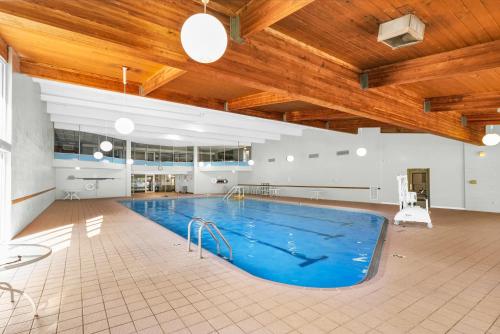 a large swimming pool in a building with a wooden ceiling at Eastlake Suites Hotel & Conference Center By OYO Urbana in Champaign