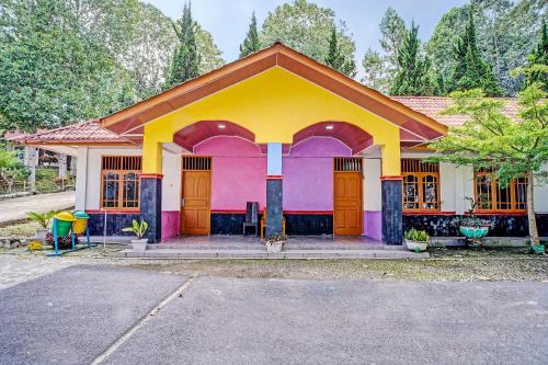 een klein huisje met een roze en gele bij Hotel O Taman Wisata Iman Ii Near Taman Wisata Iman Sitinjo in Hutamanik