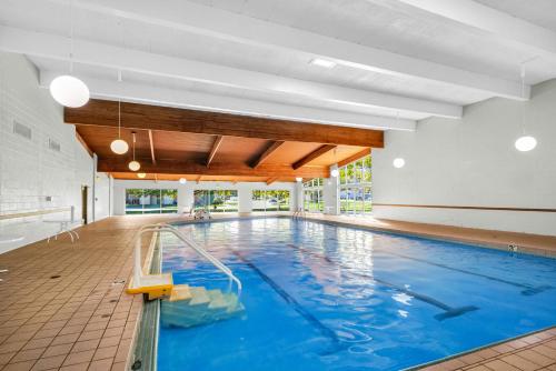 an indoor swimming pool with blue water in a building at Eastlake Suites Hotel & Conference Center By OYO Urbana in Champaign
