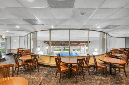 a dining room with wooden tables and chairs at Eastlake Suites Hotel & Conference Center By OYO Urbana in Champaign