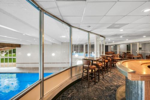 a restaurant with a swimming pool and tables and chairs at Eastlake Suites Hotel & Conference Center By OYO Urbana in Champaign