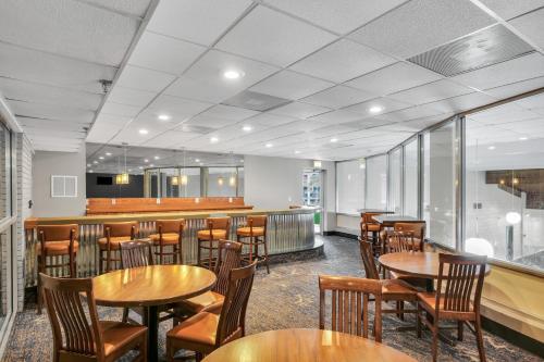 a restaurant with tables and chairs and a bar at Eastlake Suites Hotel & Conference Center By OYO Urbana in Champaign