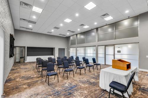 a conference room with chairs and a podium in a room at Eastlake Suites Hotel & Conference Center By OYO Urbana in Champaign