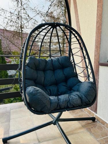 a swing chair sitting on a porch at Dom na wzgórzu z widokiem na jezioro in Brodnica Dolna