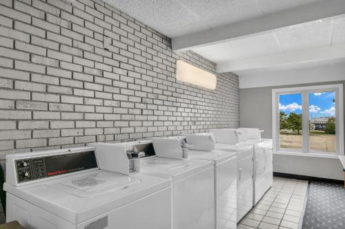 a row of white washing machines against a brick wall at Eastlake Suites Hotel & Conference Center By OYO Urbana in Champaign