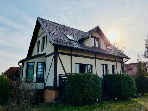 a house with a black and white at Dom na wzgórzu z widokiem na jezioro in Brodnica Dolna