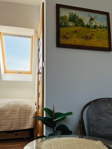 a living room with a table and a picture on the wall at Dom na wzgórzu z widokiem na jezioro in Brodnica Dolna