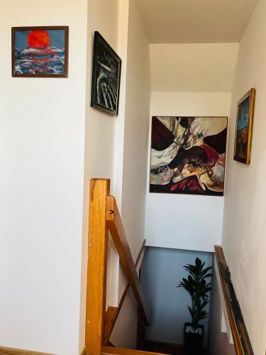 a staircase in a room with paintings on the walls at Dom na wzgórzu z widokiem na jezioro in Brodnica Dolna