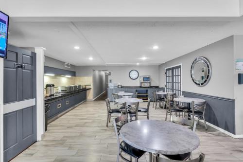 a dining room with tables and chairs and a kitchen at Eastlake Suites Hotel & Conference Center By OYO Urbana in Champaign