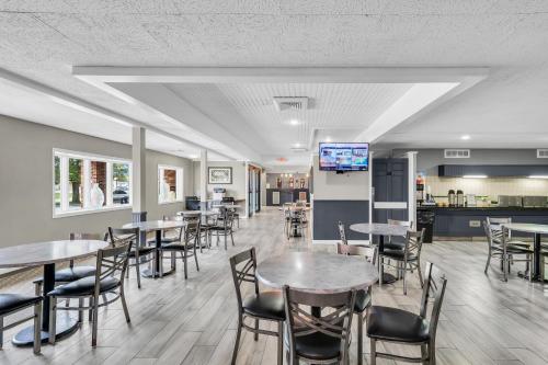 a dining room with tables and chairs and a kitchen at Eastlake Suites Hotel & Conference Center By OYO Urbana in Champaign
