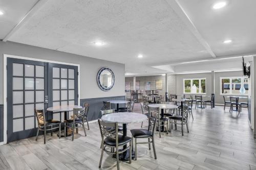 a dining room with tables and chairs and a mirror at Eastlake Suites Hotel & Conference Center By OYO Urbana in Champaign