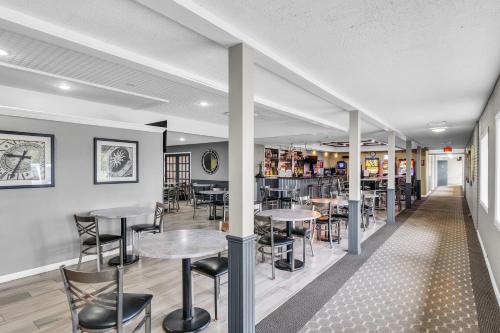 a restaurant with tables and chairs and a bar at Eastlake Suites Hotel & Conference Center By OYO Urbana in Champaign