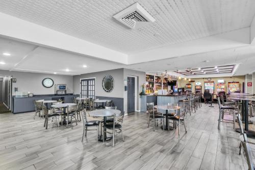 a restaurant with tables and chairs and a bar at Eastlake Suites Hotel & Conference Center By OYO Urbana in Champaign