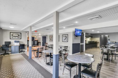a lobby with tables and chairs and a kitchen at Eastlake Suites Hotel & Conference Center By OYO Urbana in Champaign