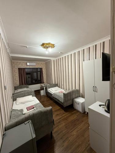 a living room with two beds and a couch at Delfin Hotel & Restaurants & Spa in Ganja