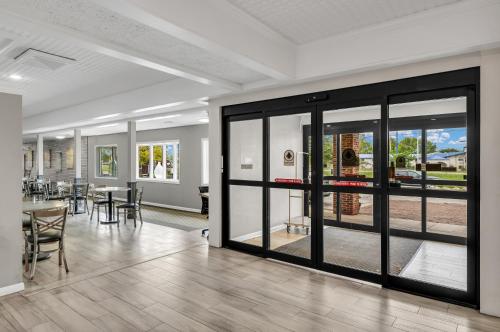 a room with glass doors with tables and chairs at Eastlake Suites Hotel & Conference Center By OYO Urbana in Champaign
