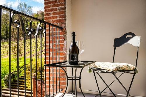 a bottle of wine sitting on a table on a balcony at Villa Clementina - Prosecco Country Hotel in San Pietro di Feletto