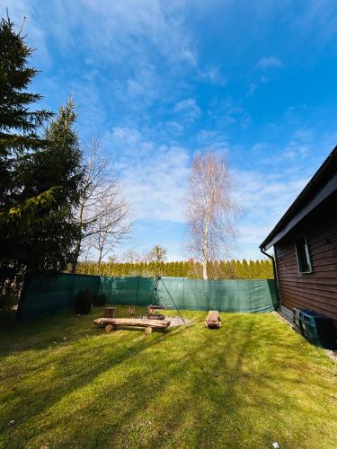 a yard with a fence and a tree at Domek Natura in Rybno