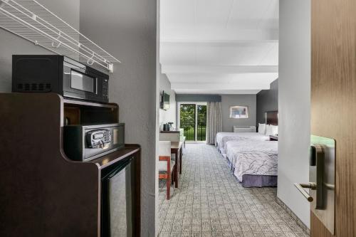 a hotel room with a bed and a room with a television at Eastlake Suites Hotel & Conference Center By OYO Urbana in Champaign