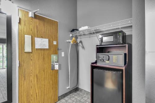 a kitchen with a refrigerator and a microwave at Eastlake Suites Hotel & Conference Center By OYO Urbana in Champaign