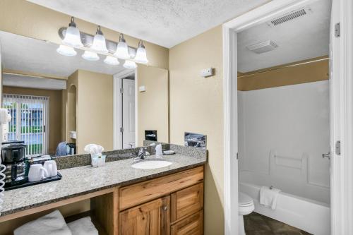 a bathroom with a sink and a mirror at Eastlake Suites Hotel & Conference Center By OYO Urbana in Champaign