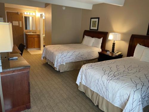 a hotel room with two beds and a table at Eastlake Suites Hotel & Conference Center By OYO Urbana in Champaign