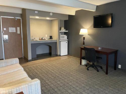 a hotel room with a desk and a table and a deskablish at Eastlake Suites Hotel & Conference Center By OYO Urbana in Champaign