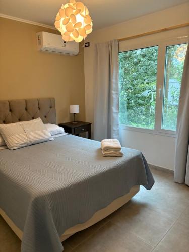 a bedroom with a bed and a large window at Flores del Cerro in Tandil