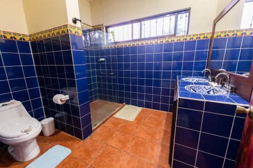 a blue tiled bathroom with a toilet and a sink at Villa Tropical By Vacation Pura Vida in Esterillos Este