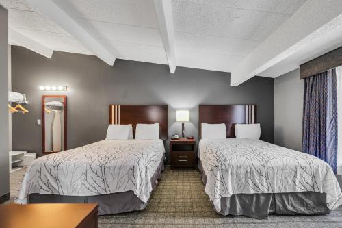 a hotel room with two beds and a table at Eastlake Suites Hotel & Conference Center By OYO Urbana in Champaign