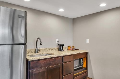 a kitchen with a sink and a refrigerator at Eastlake Suites Hotel & Conference Center By OYO Urbana in Champaign