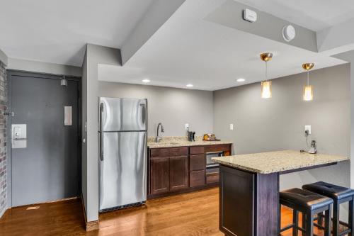 a kitchen with a stainless steel refrigerator and wooden cabinets at Eastlake Suites Hotel & Conference Center By OYO Urbana in Champaign