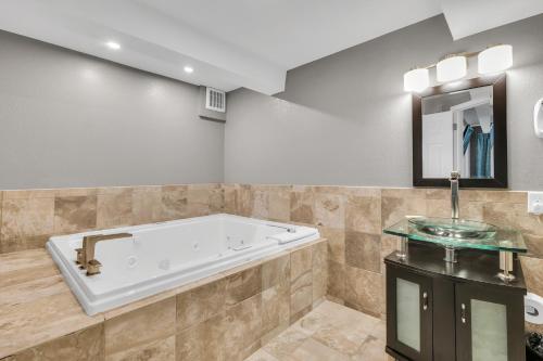 a large bathroom with a tub and a sink at Eastlake Suites Hotel & Conference Center By OYO Urbana in Champaign