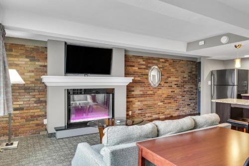 a living room with a fireplace and a tv at Eastlake Suites Hotel & Conference Center By OYO Urbana in Champaign
