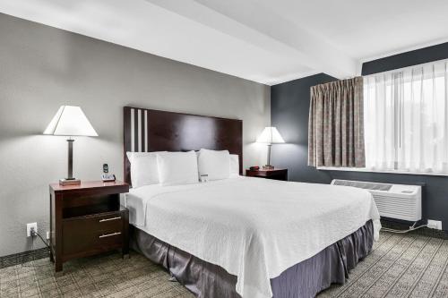 a hotel room with a large bed and a window at Eastlake Suites Hotel & Conference Center By OYO Urbana in Champaign