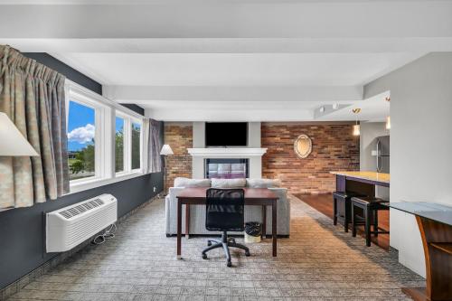a room with a bed and a desk and a kitchen at Eastlake Suites Hotel & Conference Center By OYO Urbana in Champaign