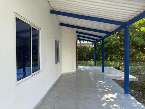 a porch of a white house with blue beams at Cabaña MARDELA Casa de Playa in San Antero