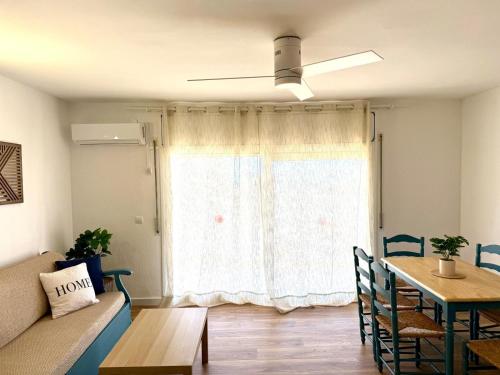 Una sala de estar con una mesa y una ventana. en Apartamentos Hesperia Palmyra, en Salou