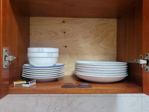 a cabinet with plates and bowls on a shelf at Biira Transit Residence Entebbe with free airport pickup in Entebbe