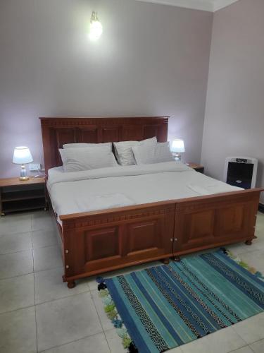 a bedroom with a large bed with white sheets and pillows at Biira Transit Residence Entebbe with free airport pickup in Entebbe
