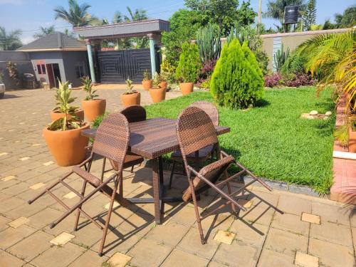 a table and two chairs sitting next to a garden at Biira Transit Residence Entebbe with free airport pickup in Entebbe