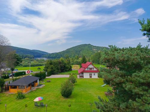 dom na zielonym polu z domem w obiekcie Drozdówka nad Soliną - Domki BOHO w Solinie