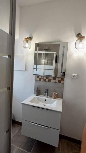 une salle de bain blanche avec un lavabo et un miroir dans l'établissement studio cosy centre ville, à Ajaccio