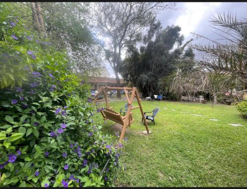 a swing set in a yard with purple flowers at Gross Nofesh and Spa Guesthouse in Bet Hillel
