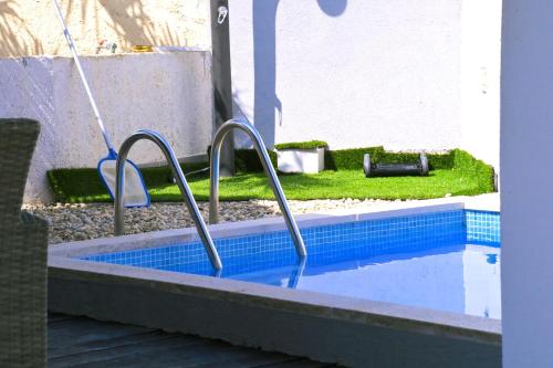 a swimming pool with two metal hand rails in it at Kuća za odmor Mumi in Gostinjac