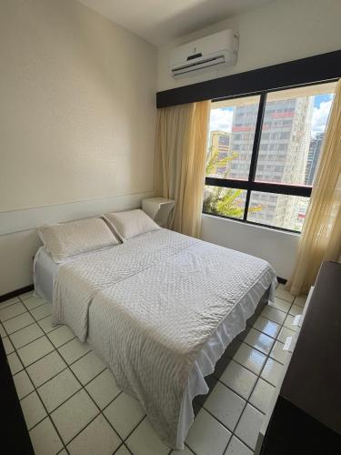 a bedroom with a white bed and a window at Navegantes apartamento in Recife