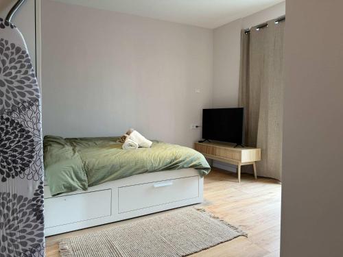 a small bedroom with a bed and a tv at The Cozy Nest Stylish and Serene City Studio in Eindhoven