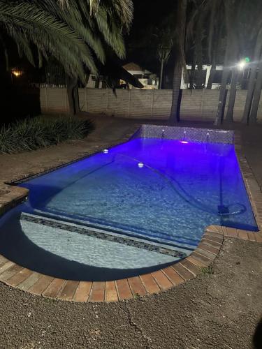 a swimming pool with purple lighting at night at The Loraine Luxury Villa in Witbank