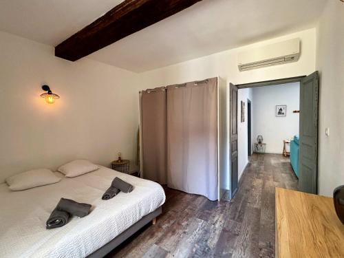 une chambre avec un lit blanc et un parquet dans l'établissement Casamea - Rue Fesch, Famille, Wifi, Clim, à Ajaccio